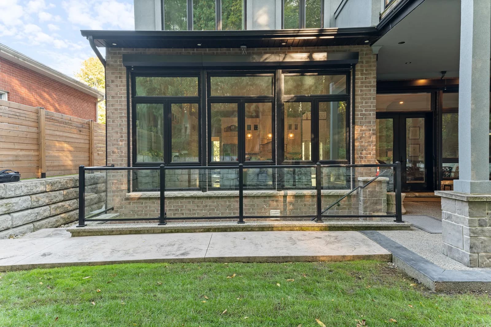 Modern patio with the aluminum roll shutters retracted, glass doors visible behind